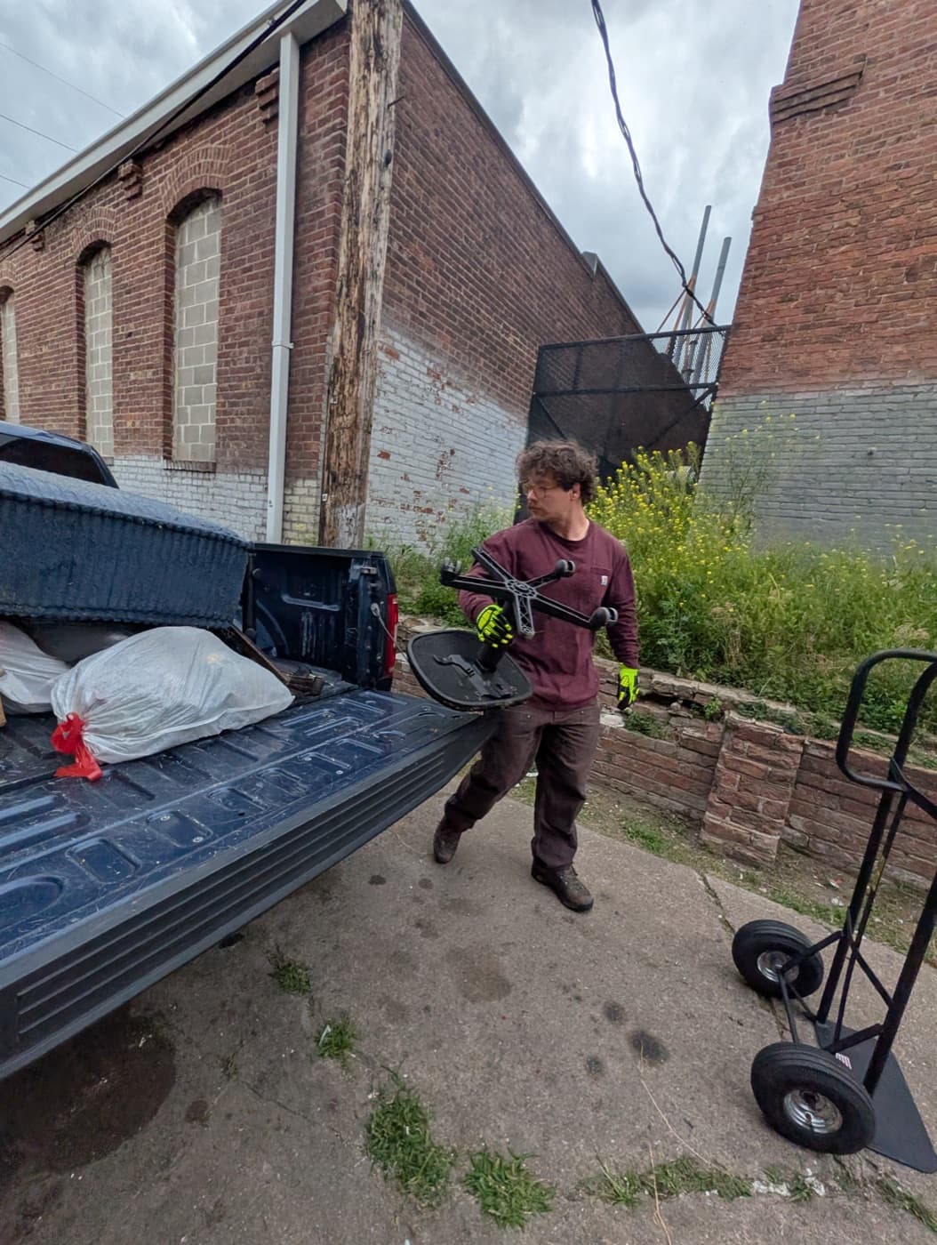 Hampton loading junk into the truck bed with the dolly nearby