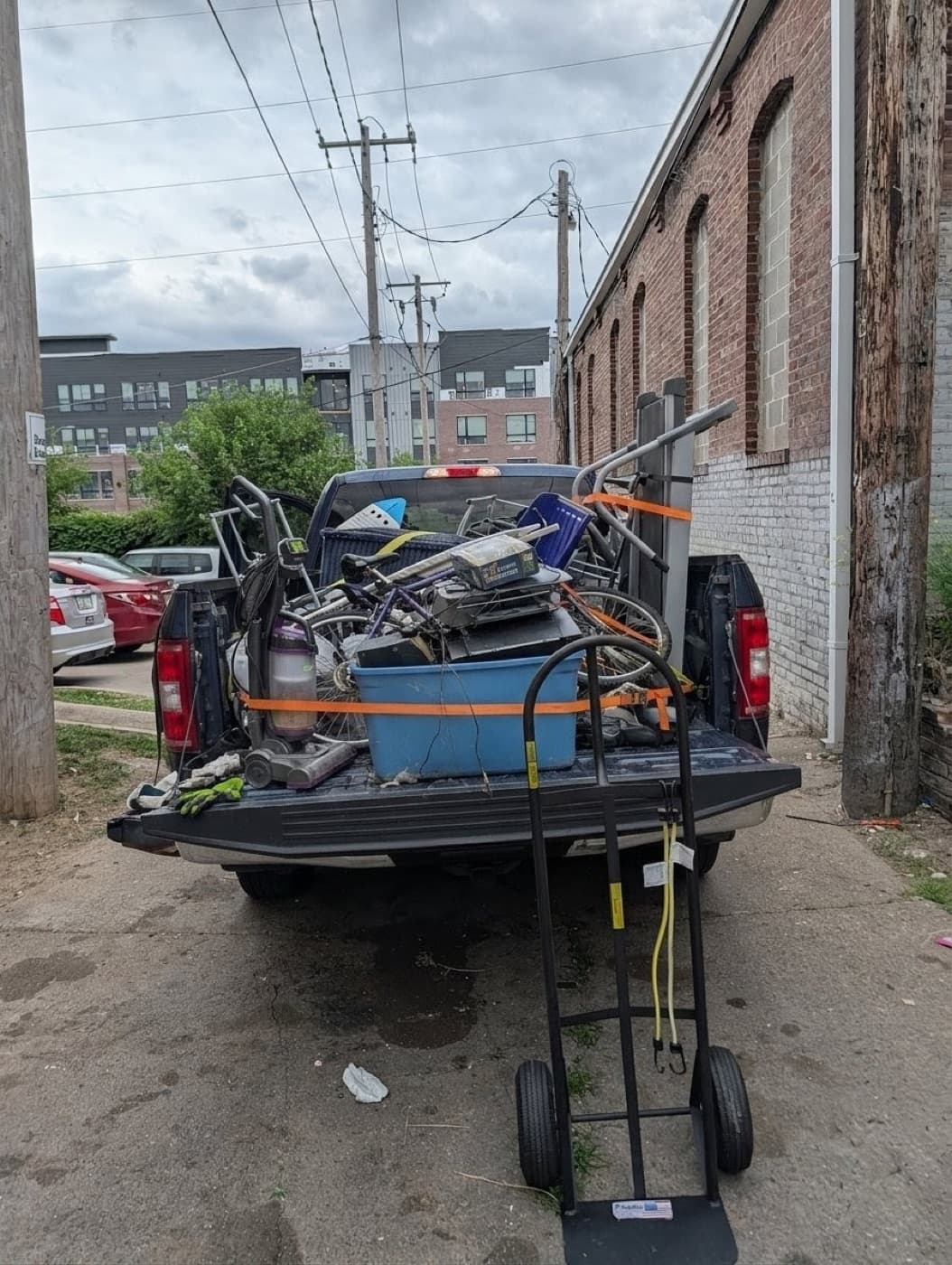 Pickup truck bed loaded with junk and strapped down with ratchet straps