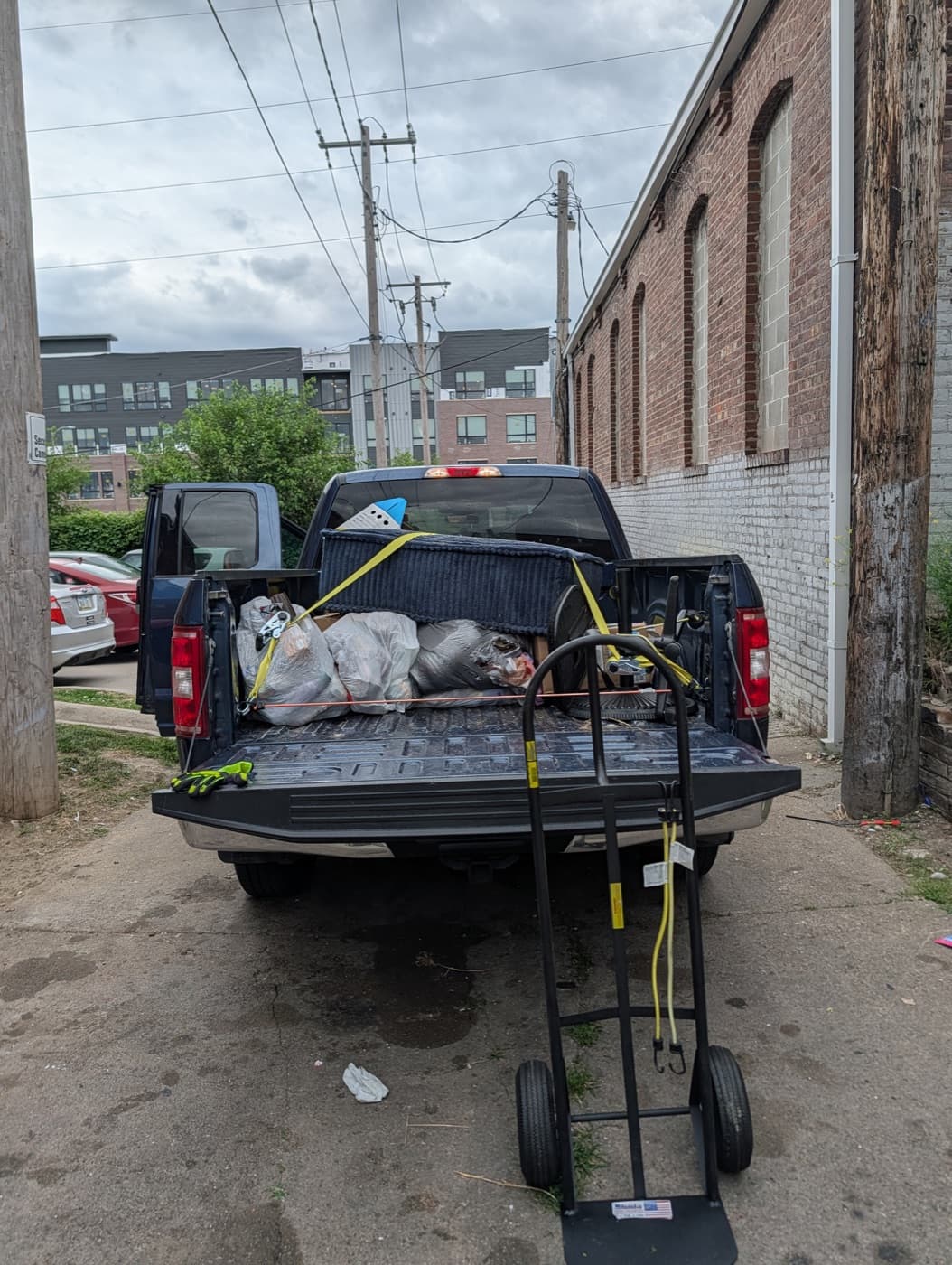 Bagged debris and old furniture loaded and secured in the truck bed